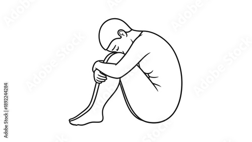 Man sitting on floor with head in knees