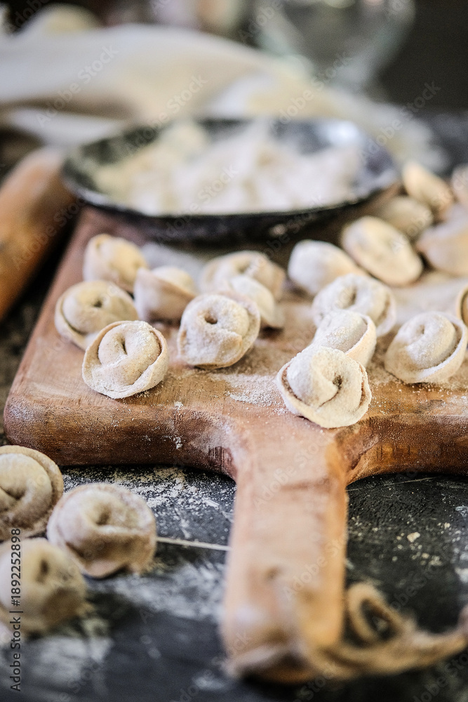 Fototapeta premium Artisan kitchen craftsmanship of tortellini with scattered flour