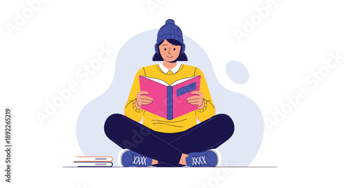 Young woman wearing a beanie and headphones sits cross-legged on the floor, deeply engrossed in reading an interesting book.