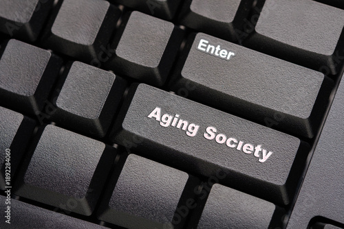 Keyboard enter key above aging society text symbolizing the transition into an older population era, highlighting demographic change, social impact, and long term challenges