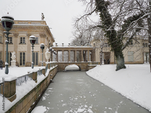Foto View of a frozen canal and a stone bridge leading to the palace in snowy Warsaw