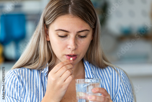 Canvas-taulu Woman taking medicine pill with water