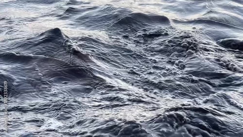 Calm ocean waves washing a rocky shore at dawn, soft pastel blue light before sunrise, minimal coastal scenery conveying freedom, travel lifestyle, nature balance, environment and relaxing seaside mor