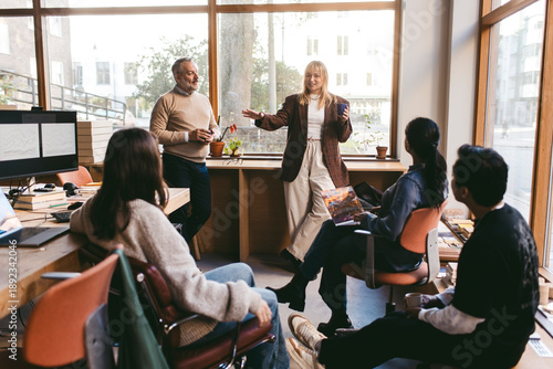 Female manager talking with colleagues during meeting in office