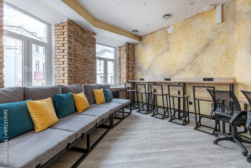 Foto Modern hostel common area with sofa and coworking workspace
