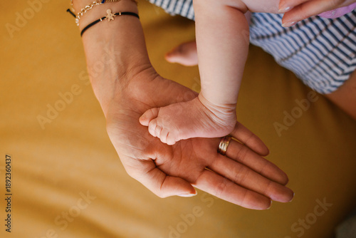 Baby Foot Resting In Open Palm Of Mother Hand