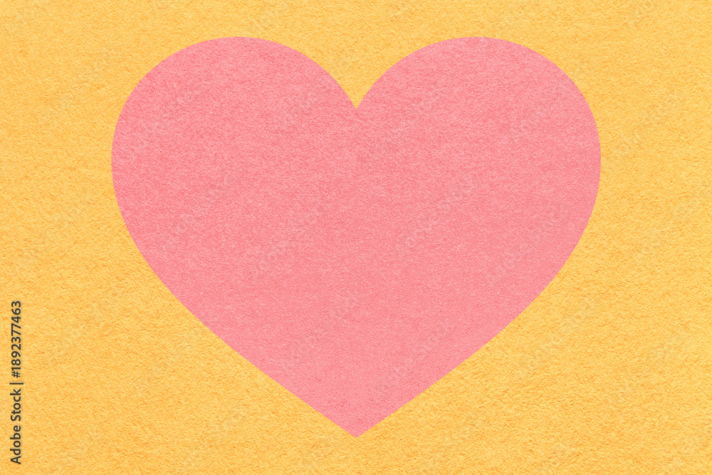Obraz premium Pink heart on light yellow paper texture background with copy space for Valentines Day banner, template or greeting card