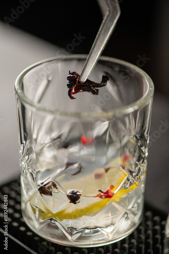 Bartender mixing gin with aromatic spices in transparent glass. Captures aroma, texture, and balance of botanical ingredients.