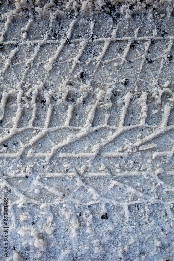 Fototapeta premium Winter Tire Tracks Texture on Icy Road Surface