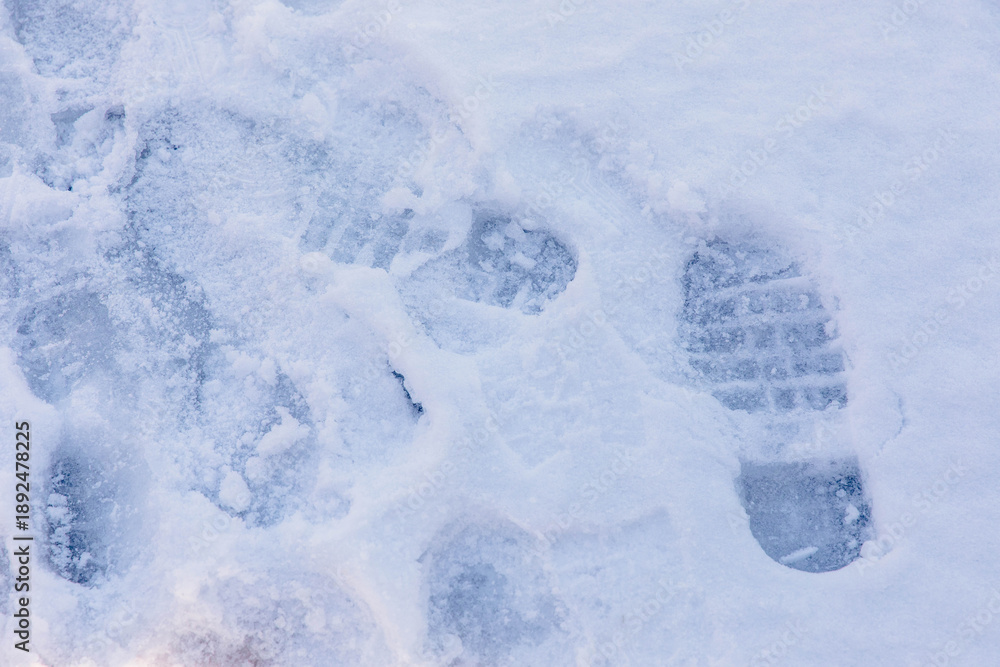 Fototapeta premium Snow-covered footprints on winter ground