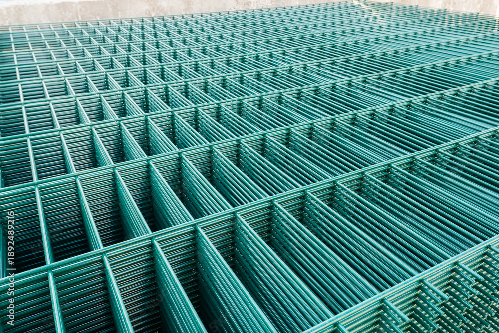 Fototapeta premium Selective focus on metal lattice fencing modules with green rectangular cells