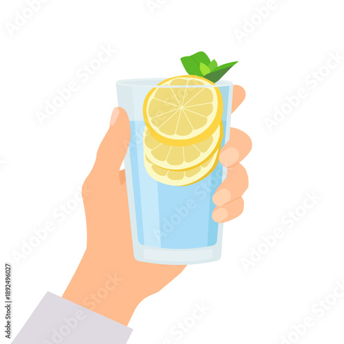 Hand holding a glass of lemon water with miint. Water balance, drink more water concept