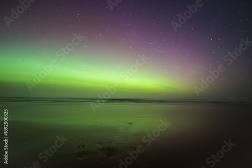 Tableau sur toile The sky is filled with stars and the horizon is green