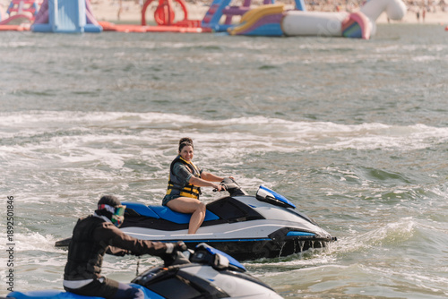 Εκτύπωση καμβά Two individuals riding jet skis on a water surface with inflatable water park st