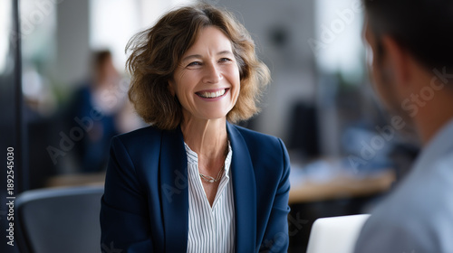 Experienced HR specialist in navy blazer explaining detailed employment procedures to attentive candidate comprehensive recruitment process discussion sleek corporate office sett