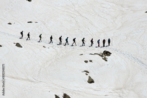 Fotografia Hikers in a snowy pathway in the Alps