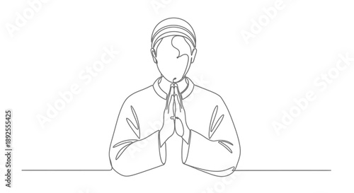 Serene young man in prayer with hands clasped in calm contemplation