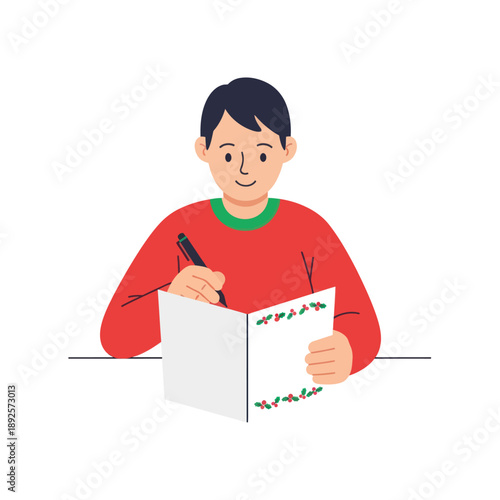 Young boy writing in a holiday card with a smile while seated  