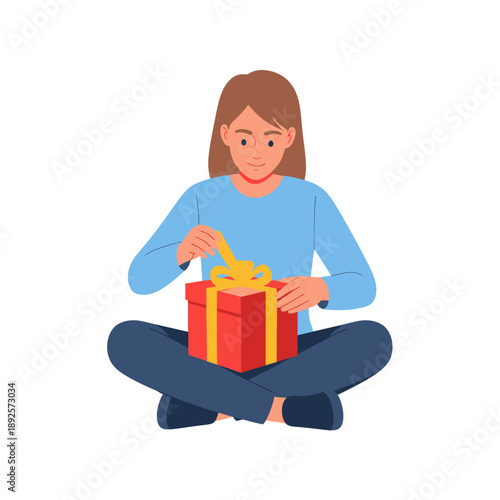 Young girl opening a red gift box while sitting on the floor  