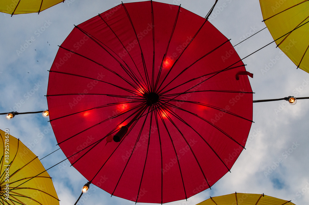 Fototapeta premium Street decorations in the form of suspended umbrellas illuminated by LED lamps