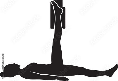 Silhouette of woman practicing Legs Up the Wall yoga pose Viparita Karani with wall support