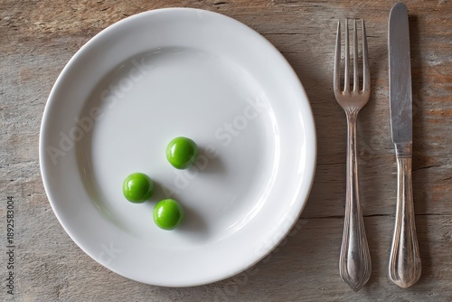 Wallpaper Mural Three peas on a white plate with knife and fork as a visual metaphor for limited nutrition Torontodigital.ca