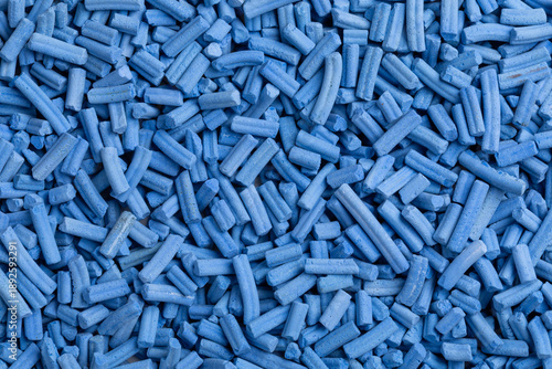 Φωτογραφία A top-down macro photo shows a dense, uniform layer of light blue cylindrical industrial catalyst pellets with a matte, porous texture