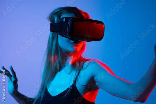 Woman interacting in virtual space with VR headset and extended arm, immersive metaverse technology concept