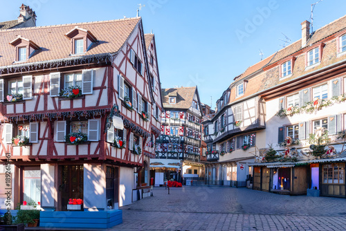 Characteristic Alsatian buildings with sloping roofs and half-timbered facades, richly decorated to celebrate Christmas

