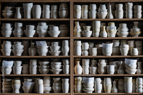 Fotografie Pottery workshop interior with handmade ceramic cups on clay wheels