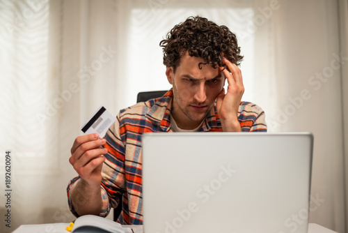 Wallpaper Mural Worried entrepreneur using credit card and laptop at his home office. He is having problems with electronic banking while working remotely.	 Torontodigital.ca