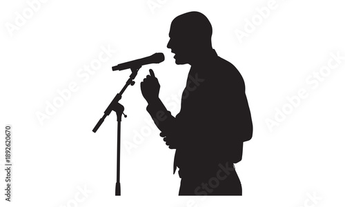 Silhouette of a man in a suit speaking into a microphone, gesturing with finger.