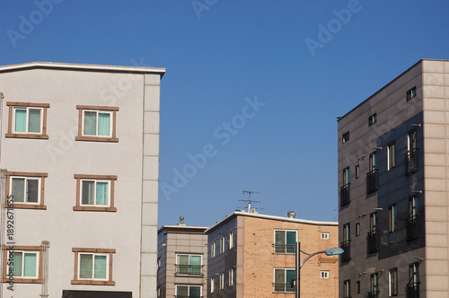 Residential buildings under clear blue sky with copy space