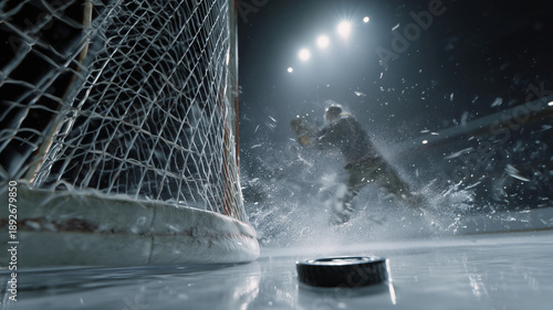 Close-up view of a hockey puck resting on the ice rink near the goal