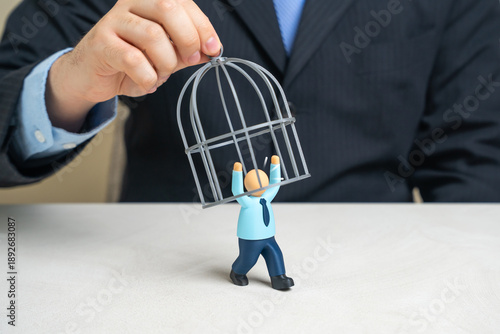 A businessman is trying to cage an office worker to retain valuable employees. Talent retention pressure, toxic control metaphor and ethical boundaries. Workforce freedom, motivation loss