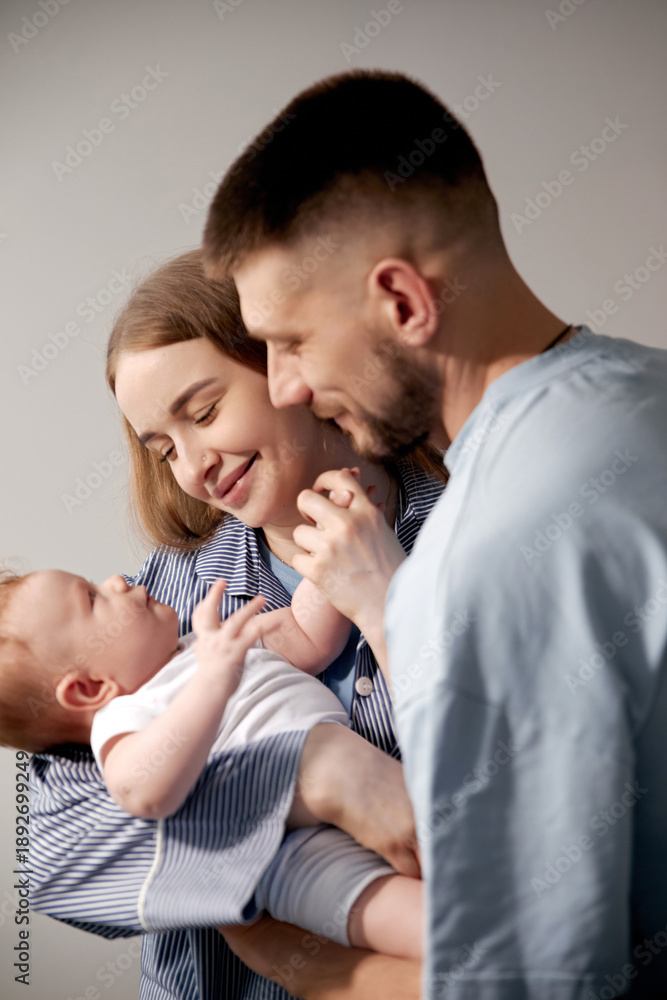Fototapeta premium Loving parents joyfully interacting with their newborn baby in a cozy home environment, showcasing the beauty of family bonding and nurturing moments, family love concept