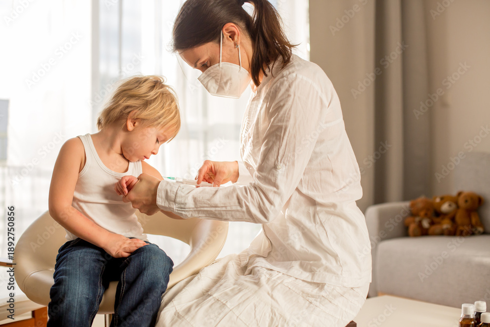 Fototapeta premium Little toddler boy, getting injection in consulting room from pediatrition