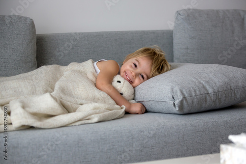 Fotografija Blond toddler child, wiping his nose in a tissue, sneezing and coughing