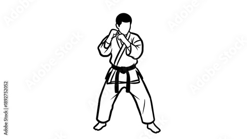 Karate martial artist in defensive pose with traditional gi and black belt