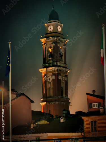 The bell tower of the church of Cairo Montenotte with its reflection in the Bormida River during a warm August evening during the celebrations of San Lorenzo, the patron saint of Cairo Montenotte