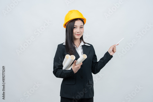 The female executive is reviewing a blueprint report, guiding the industry with a strategic vision and ensuring sustainable global growth to power the company's future.