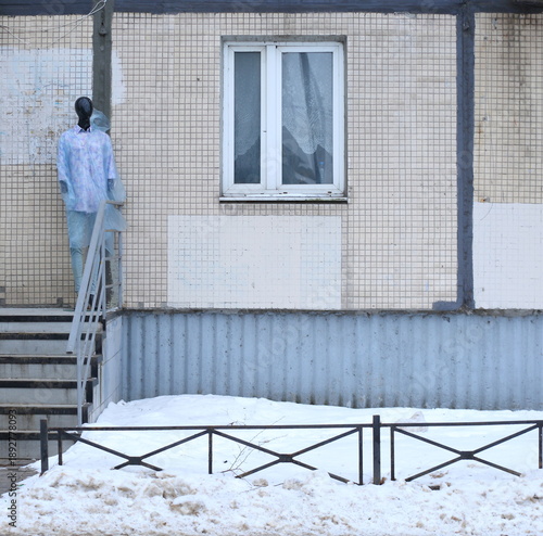 The mannequin is standing on the porch steps