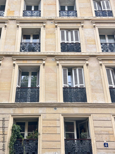 Facades of beautiful old buildings with French windows and shutters, Paris, France.