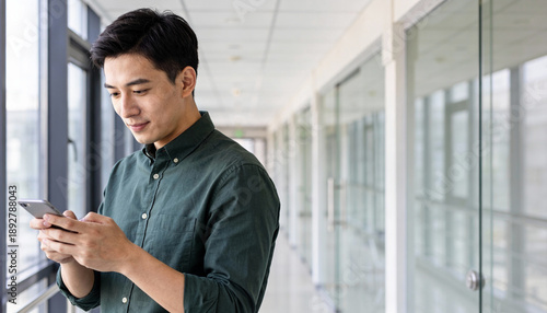 Man checking notifications on smartphone in contemporary coworking space
