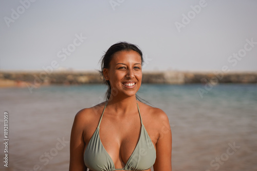 Photography Happy young latin woman smiling on camera on the beach during summer vacation -