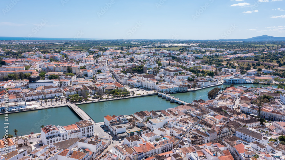 Obraz premium Tavira, a historic town in Algarve, Portugal, captured by a drone. You can see the buildings, Gilao river, and landscape on a sunny day