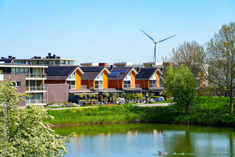 Obraz premium Modern sustainable neighborhood in Brielle with solar panels and wind turbine, South Holland, the Netherlands