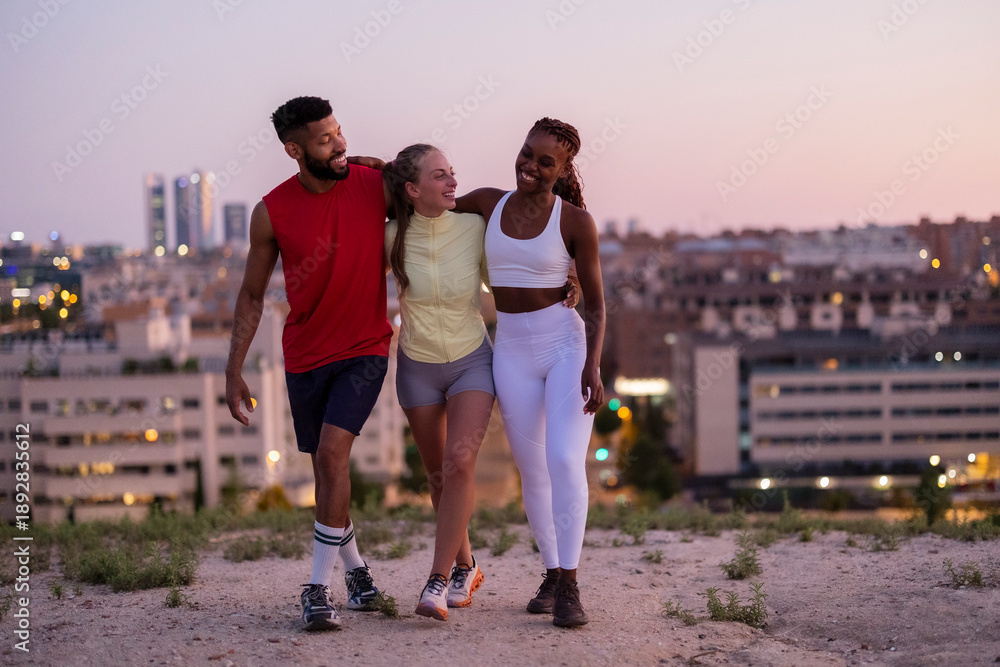 Obraz premium Diverse friends walking together laughing during sunset