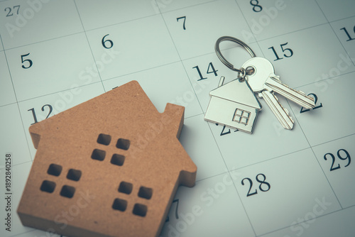 House and key on white calendar background. Mortgage loan for buying home or real estate property, home finance, money saving planning, money risk management, installment schedule and so on concept.