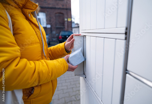 Girl Retrieves A Delivered Parcel From An Online Shop At A Parcel Automated Locker
